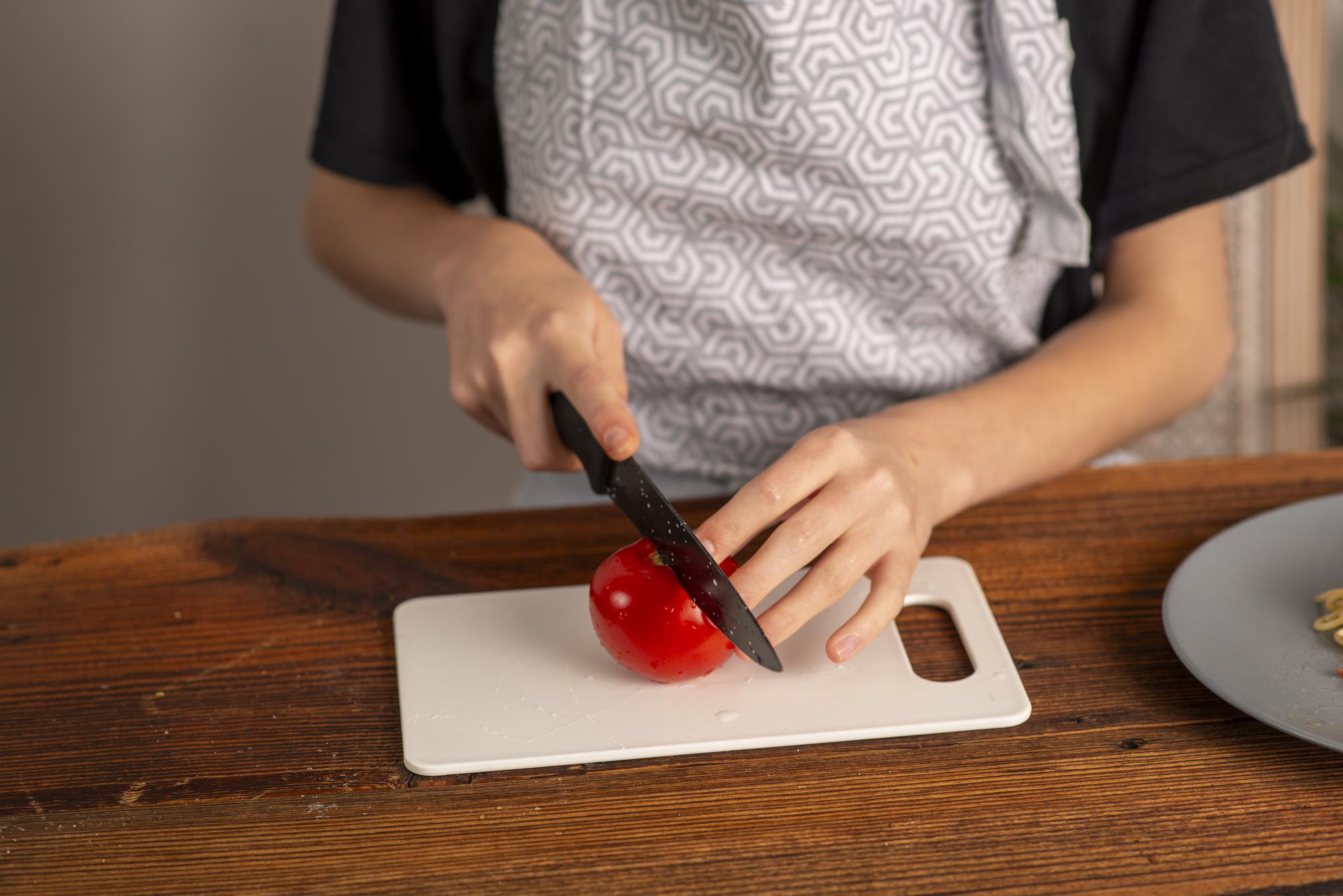 Student practicing knife skills on cutting board